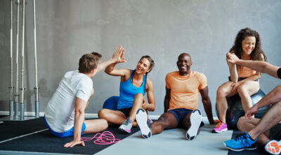 Friends,In,Sportswear,High,Fiving,And,Laughing,Together,While,Sitting